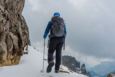 Rear view of man standing on snowcapped mountain