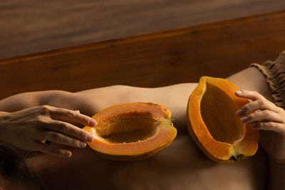 Cropped hand of woman holding pumpkin