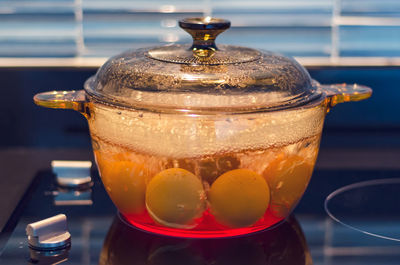 Eggs in boiling water on modern kitchen stove, shallow depth of field