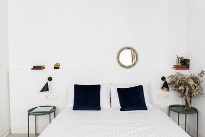 Comfortable bed with white duvet in cozy bedroom of modern apartment