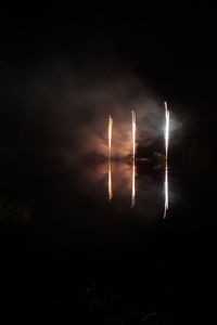 Firework display over sea against sky