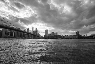 Sea by buildings against sky in city