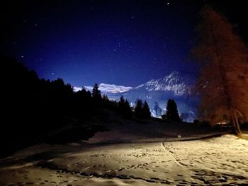 Scenic view of snowcapped mountains against sky at night