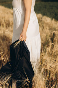 Midsection of woman standing on field