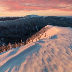 Scenic view of snowcapped mountains against sky during sunset