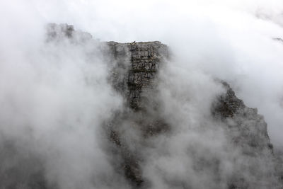 Aerial view of mountain amidst fog