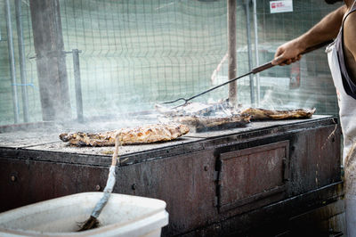 Man preparing meat on barbecue grill