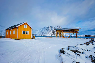 Rorbu house and drying flakes for stockfish cod fish in winter. lofoten islands, norway
