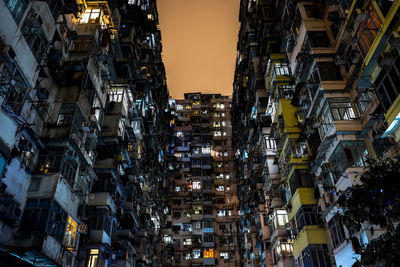 Low angle view of buildings in city at dusk