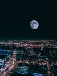 Illuminated cityscape against sky at night