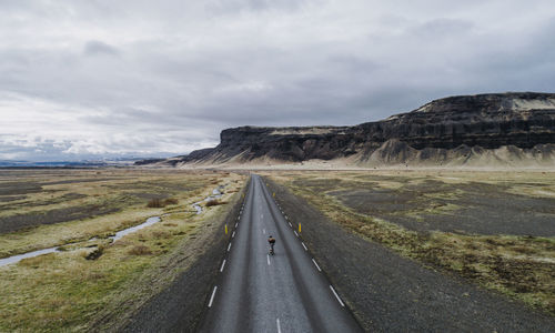 Aerial view of man skateboarding on road against sky and mountain