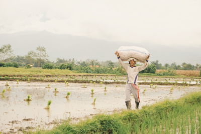 Full length of man standing on field against sky