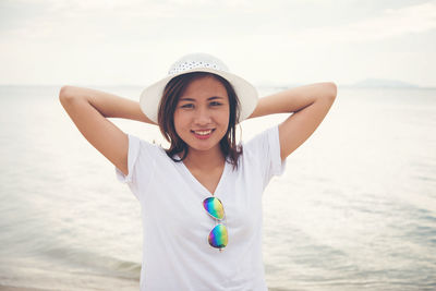 Portrait of woman at beach against sky