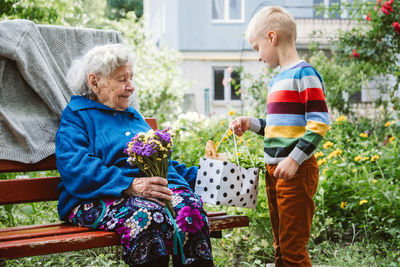 90 year old great-grandmother, grandmother with grandson together. grandson hugs