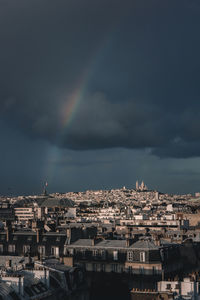 Aerial view of rainbow over city against sky
