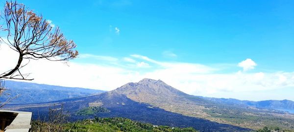 Scenic view of mountains against blue sky