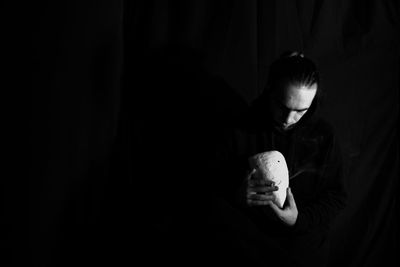 Portrait of woman holding toy in darkroom