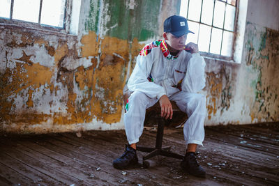 Full length of man sitting on wall