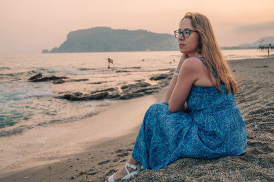 Portrait of woman standing at sandy beach