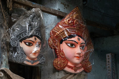 Face of goddess idol decorated with crown and aesthetics hanging on a wall for sale 