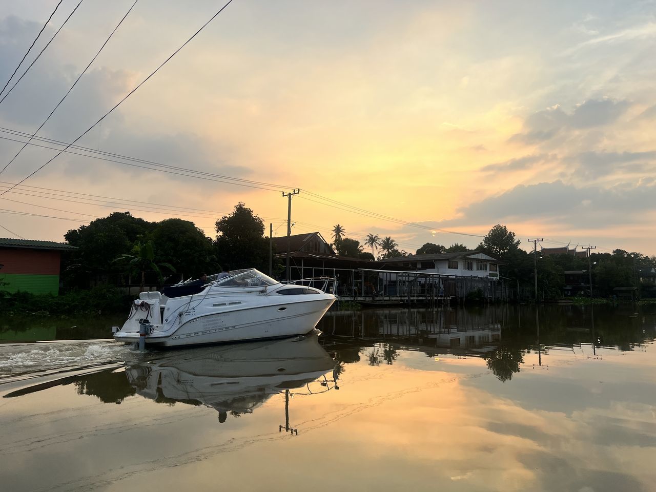 water, reflection, sky, sunset, nautical vessel, transportation, cloud, nature, mode of transportation, sea, vehicle, dusk, architecture, evening, environment, beauty in nature, tranquility, boat, landscape, dock, shore, no people, scenics - nature, built structure, sun, twilight, ship, travel, tree, outdoors, travel destinations, reflection lake, building, house, sunlight, moored, watercraft, horizon, tranquil scene, building exterior, dramatic sky, city, plant, fishing