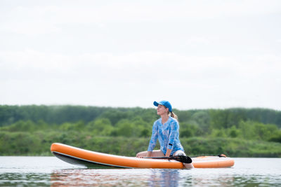 Rear view of woman kayaking in lake