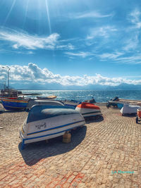 Boats moored on beach against sky