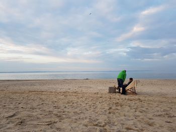 People at beach against sky