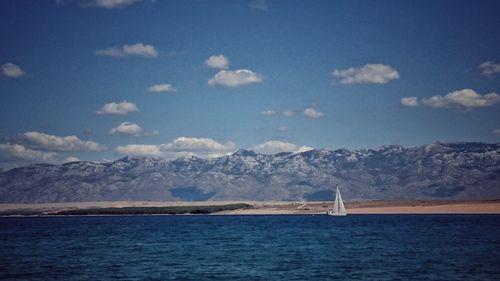 Scenic view of sea and mountains against sky