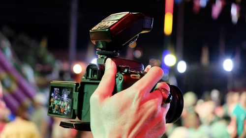 Cropped hand of person photographing at night