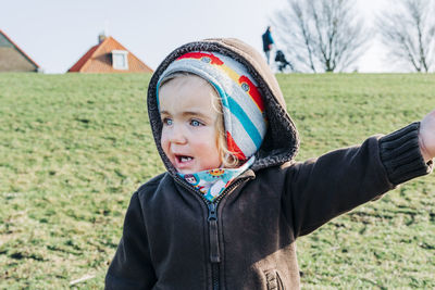 Portrait of boy looking away on field