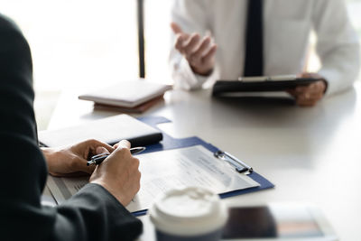 Midsection of man using mobile phone on table