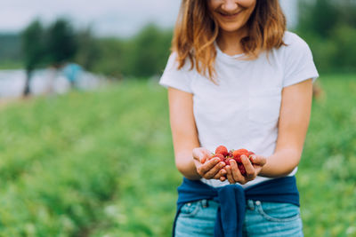 Woman is holding ripe red strawberries at a u-pick farm in washington