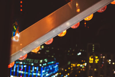 Close-up of illuminated lighting equipment in city at night