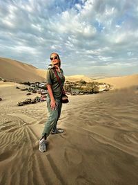 Full length of woman standing at desert