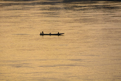 Silhouette boat in sea during sunset