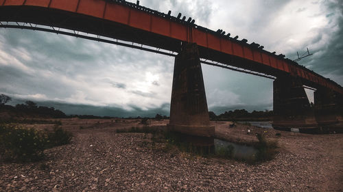 Low angle view of bridge over river against sky