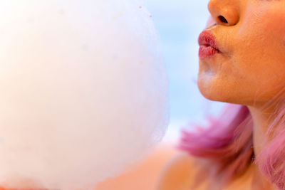 Close-up of woman blowing cotton candy