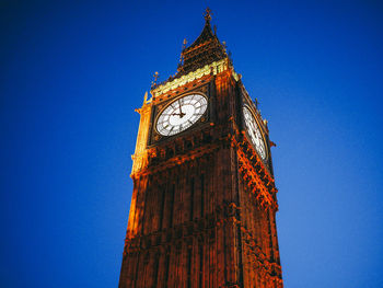 Low angle view of clock tower against blue sky