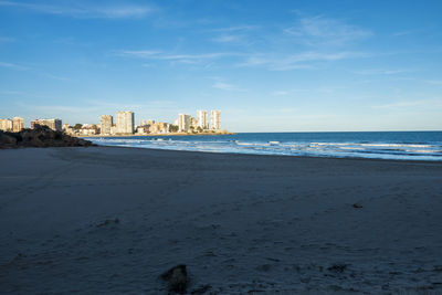 Scenic view of sea by buildings against sky