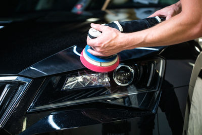 Cropped hand of man repairing car