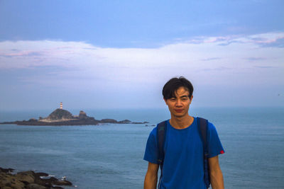 Man standing at beach against sky