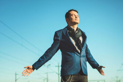 Well dressed man standing against blue sky