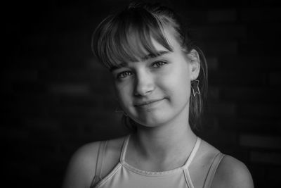 Portrait of smiling woman against black background