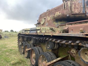 Old abandoned truck on field against sky