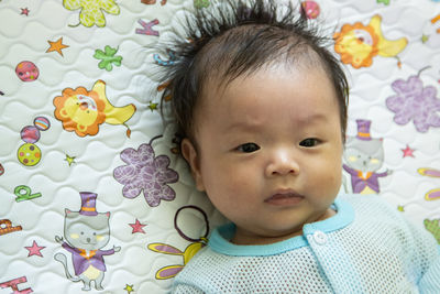 Portrait of cute baby lying on bed