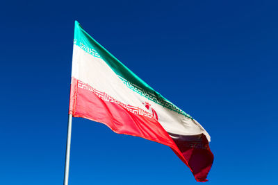 Low angle view of flag against blue sky