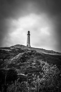 Lighthouse on mountain against sky