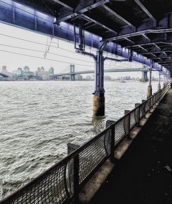Bridge over sea against sky in city