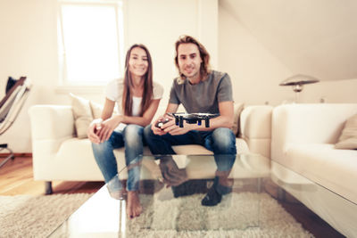 Young couple sitting on sofa at home